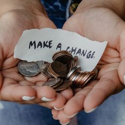 image of person holding coins and make a change sign