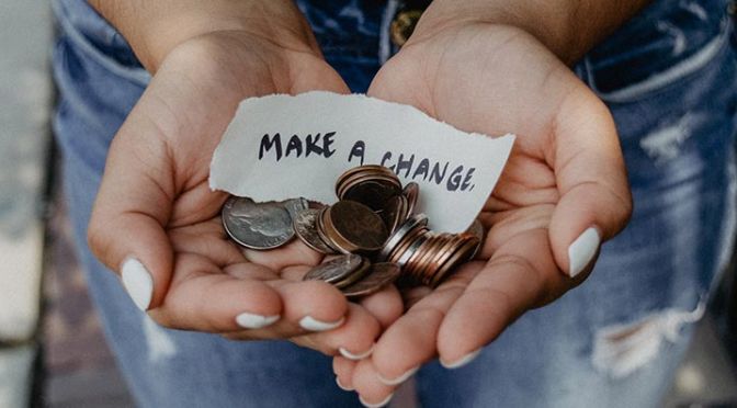 image of person holding coins and make a change sign