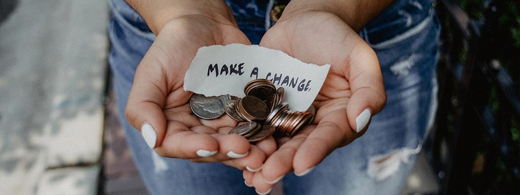 image of person holding coins and make a change sign